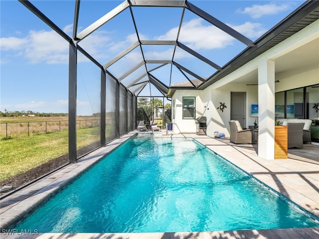 view of pool featuring ceiling fan, glass enclosure, and a patio area