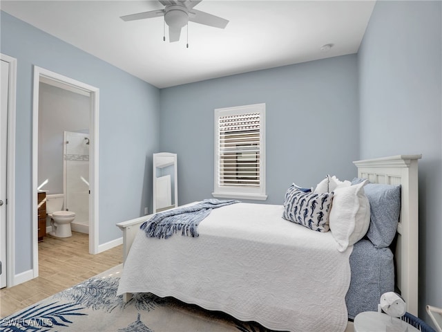 bedroom with ceiling fan, connected bathroom, and light wood-type flooring