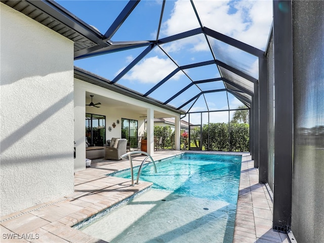 view of swimming pool with ceiling fan, a patio, an outdoor living space, and glass enclosure