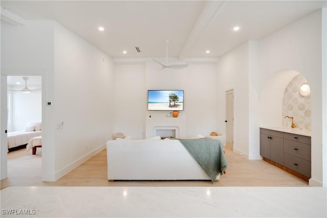 living area featuring baseboards, light wood finished floors, beam ceiling, and recessed lighting