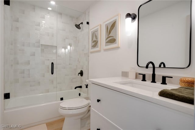 full bath featuring shower / bath combination with glass door, vanity, toilet, and wood finished floors