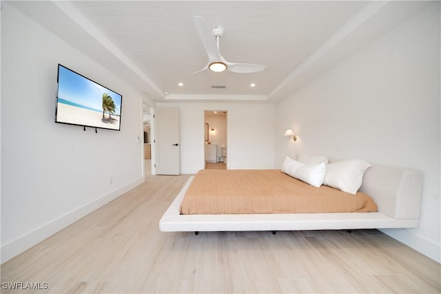 unfurnished bedroom featuring light wood-type flooring, a raised ceiling, visible vents, and baseboards