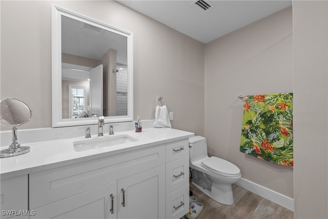 bathroom with vanity, toilet, and hardwood / wood-style floors