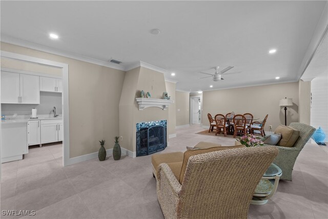 tiled living room featuring sink, ornamental molding, and ceiling fan