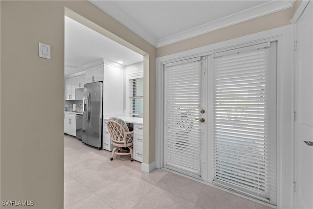 tiled entrance foyer featuring crown molding and built in desk