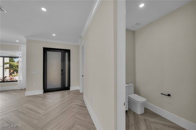 interior space with light parquet floors and ornamental molding