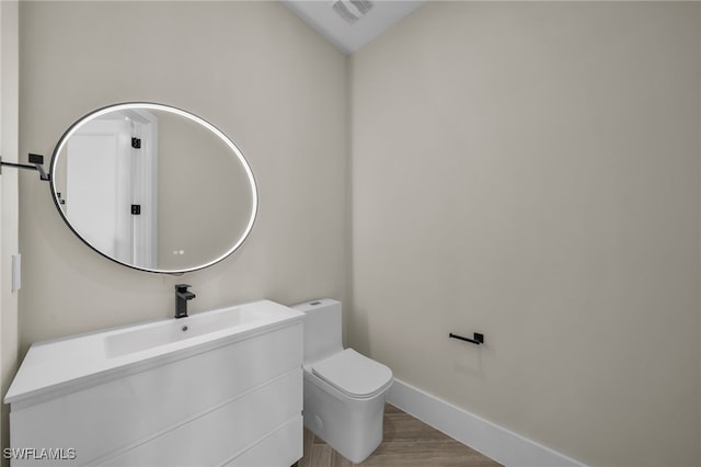 bathroom with vanity, wood-type flooring, and toilet