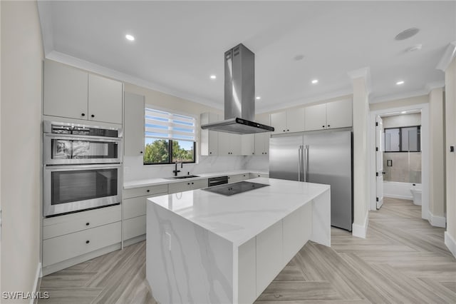 kitchen featuring a kitchen island, island range hood, white cabinets, stainless steel appliances, and light parquet flooring