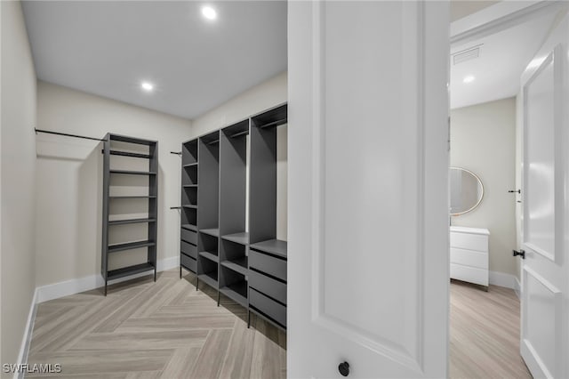 spacious closet with light parquet flooring