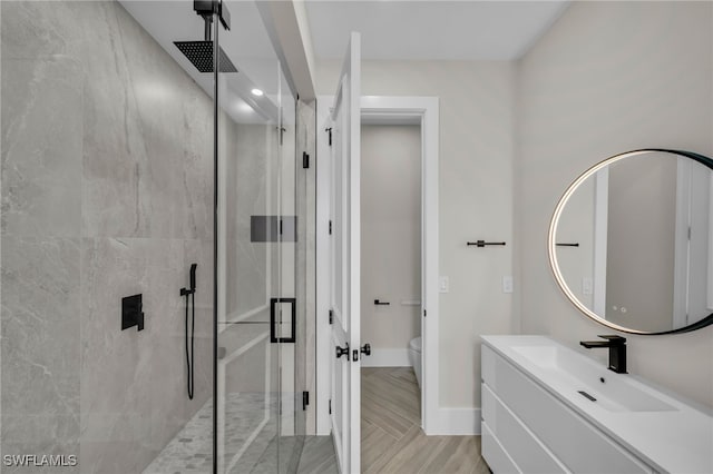 bathroom with vanity, a shower with shower door, and toilet