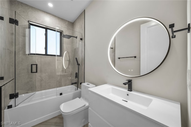 full bathroom featuring toilet, vanity, bath / shower combo with glass door, and hardwood / wood-style flooring