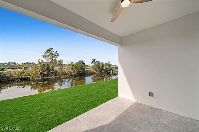 view of yard with a patio, ceiling fan, and a water view