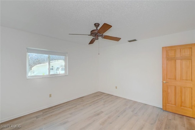 empty room featuring ceiling fan, light hardwood / wood-style floors, and a textured ceiling