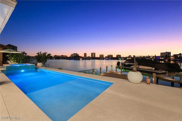 pool at dusk featuring a water view and a dock