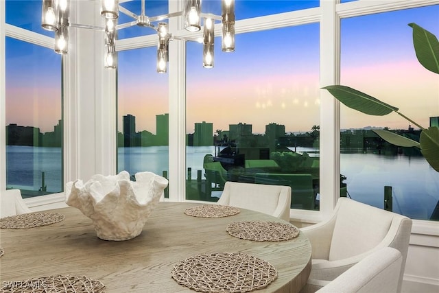 sunroom with a chandelier and a water view