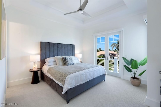 carpeted bedroom featuring a raised ceiling, access to exterior, and ceiling fan