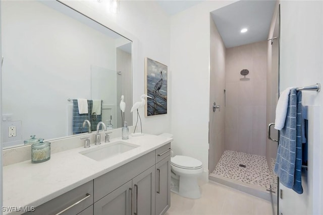 bathroom featuring vanity, toilet, tile patterned flooring, and a shower with door