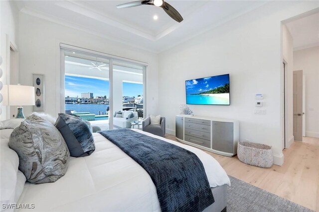 bedroom featuring ornamental molding, a raised ceiling, ceiling fan, access to exterior, and hardwood / wood-style floors