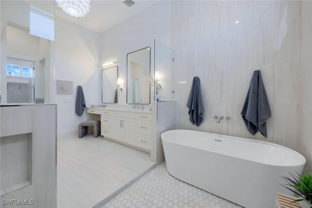 bathroom with a washtub, vanity, and an inviting chandelier