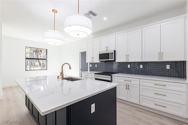 kitchen with white cabinets and a center island with sink