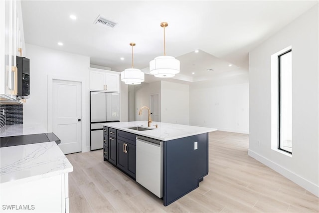 kitchen featuring dishwasher, sink, white cabinets, hanging light fixtures, and a center island with sink