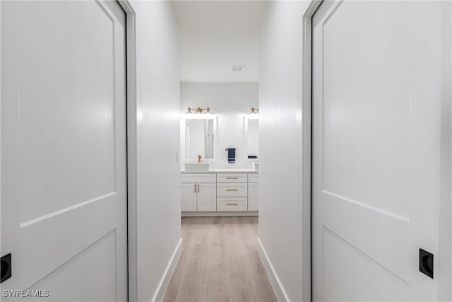 corridor featuring light hardwood / wood-style floors and sink