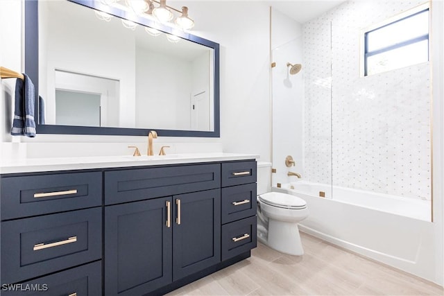 full bathroom with tiled shower / bath, vanity, toilet, and wood-type flooring