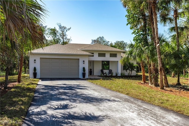 view of front of home with a garage and a front lawn