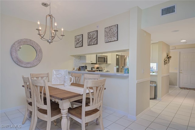 dining area featuring light tile patterned floors and a chandelier