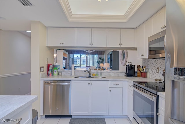 kitchen with white cabinetry, stainless steel appliances, a raised ceiling, and sink