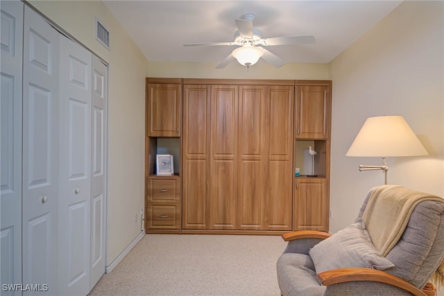 sitting room featuring light colored carpet and ceiling fan