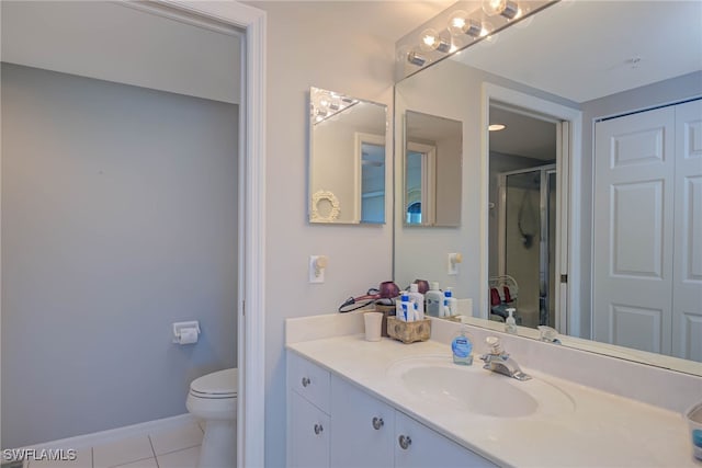 bathroom featuring tile patterned flooring, vanity, a shower with door, and toilet