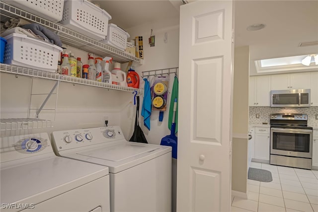 washroom with washing machine and dryer and light tile patterned flooring