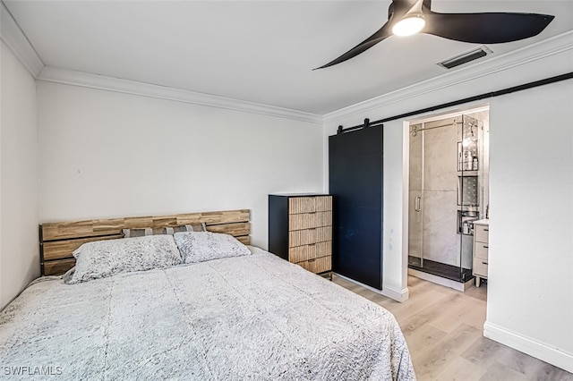 bedroom featuring connected bathroom, ceiling fan, light hardwood / wood-style floors, crown molding, and a barn door