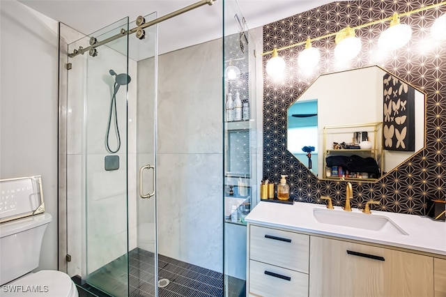 bathroom featuring vanity, toilet, and a shower with shower door