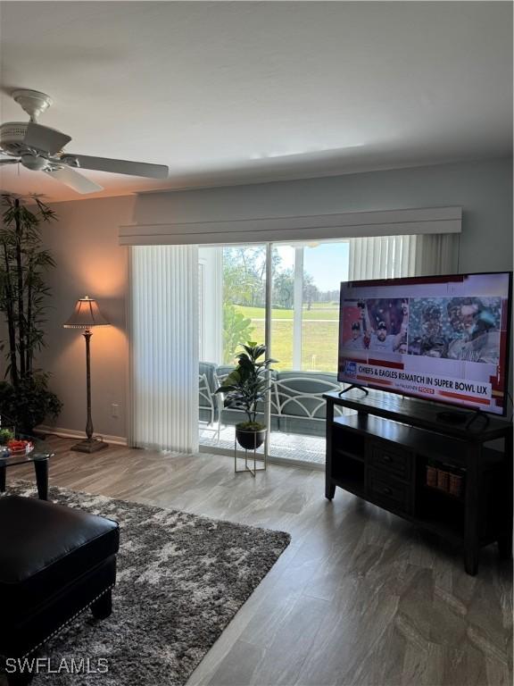 living room with wood-type flooring and ceiling fan