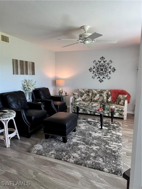 living room featuring ceiling fan and hardwood / wood-style floors