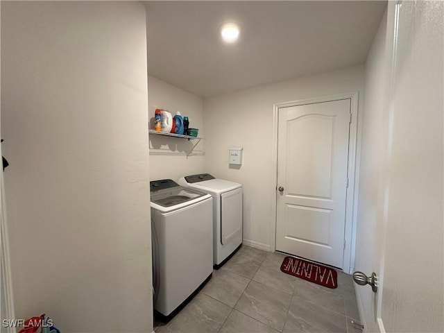 laundry area with washing machine and clothes dryer and light tile patterned floors