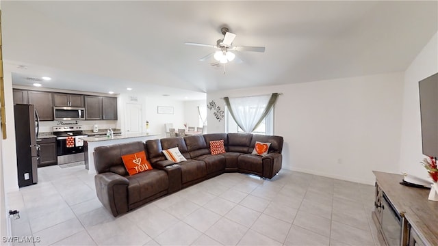 living room featuring lofted ceiling, ceiling fan, and light tile patterned flooring