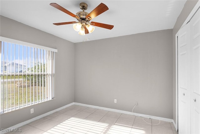 empty room featuring ceiling fan and light tile patterned floors