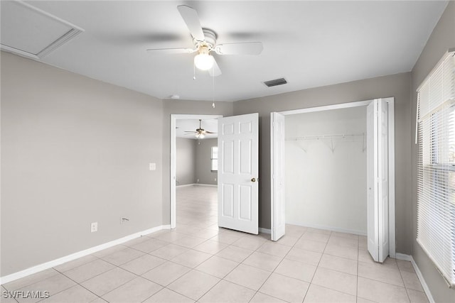 unfurnished bedroom with multiple windows, light tile patterned flooring, ceiling fan, and a closet