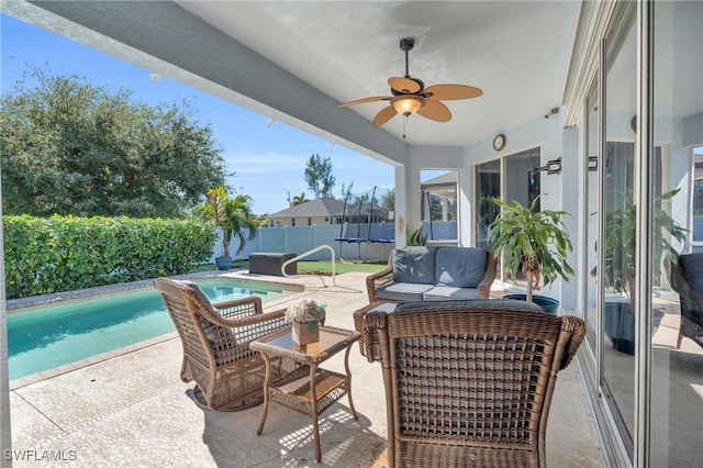 view of patio featuring a swimming pool with hot tub, a trampoline, and an outdoor hangout area