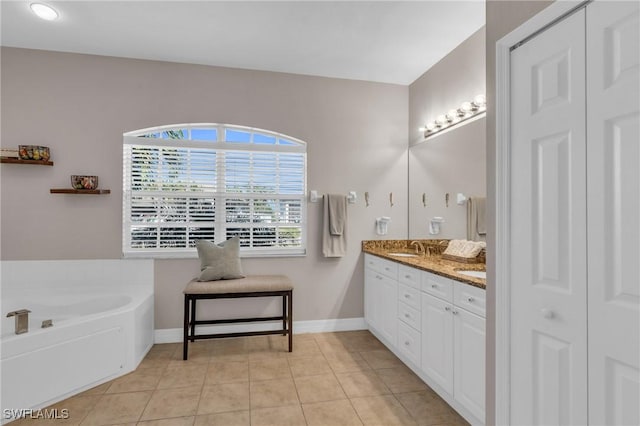 bathroom featuring tile patterned flooring, vanity, and a tub