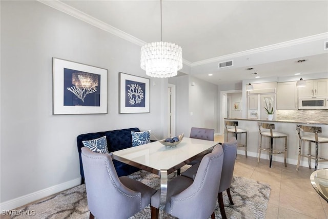 dining space featuring an inviting chandelier, ornamental molding, and light tile patterned floors