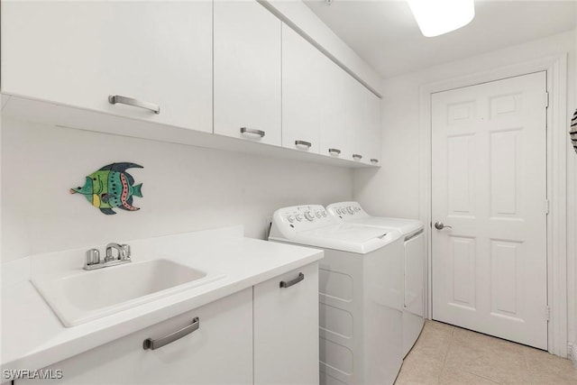 washroom featuring cabinets, washing machine and dryer, sink, and light tile patterned floors