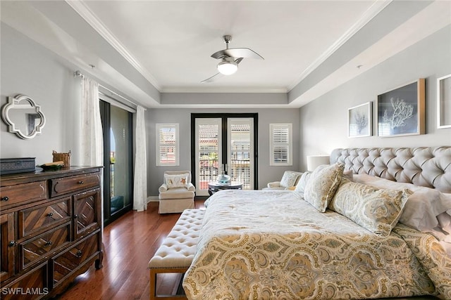 bedroom featuring dark hardwood / wood-style flooring, access to exterior, crown molding, and a raised ceiling