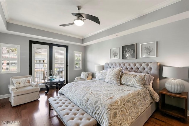 bedroom with ceiling fan, a tray ceiling, ornamental molding, dark hardwood / wood-style flooring, and access to outside