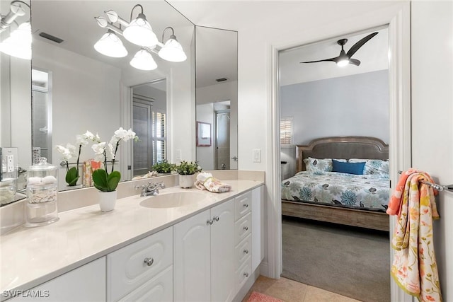 bathroom with ceiling fan with notable chandelier, vanity, and tile patterned flooring