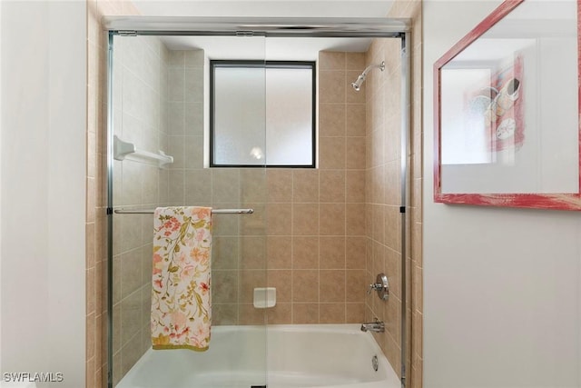 bathroom with bath / shower combo with glass door