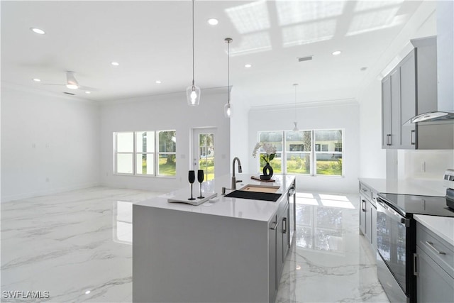 kitchen with sink, gray cabinets, a kitchen island with sink, hanging light fixtures, and stainless steel appliances